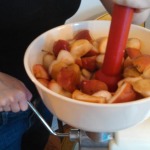 Smushing the cooked apples into the hopper. 